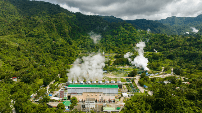 In Negros, Philippines, there is a geothermal station with steam and pipes visible.