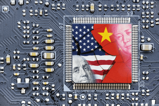 US and China flags on a processor, CPU, or GPU microchip on a motherboard: American firms experience collateral damage amid US-China tech conflict as the US imposes restrictions on AI chip sales to China.