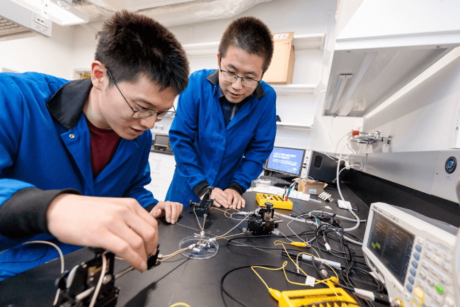 Asst. Prof. Sihong Wang and PhD student Yahao Dai inspecting a wearable neuromorphic device (Photo credit: John Zich).