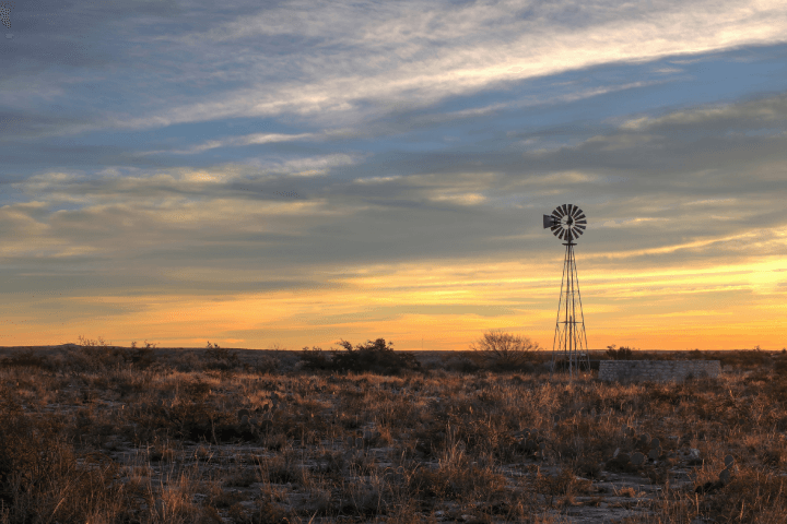 A windmill bathed in the glow of sunrise near Seminole Canyon, situated close to the border of Texas and Mexico.