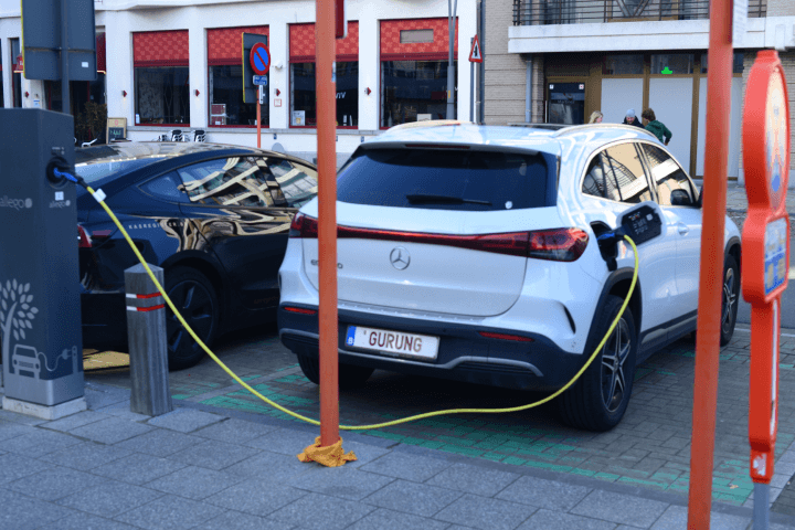 Black Tesla Dual motor car and Mercedes-Benz hybrid car at a street charging station in Blankenberge, West-Flanders, Belgium.