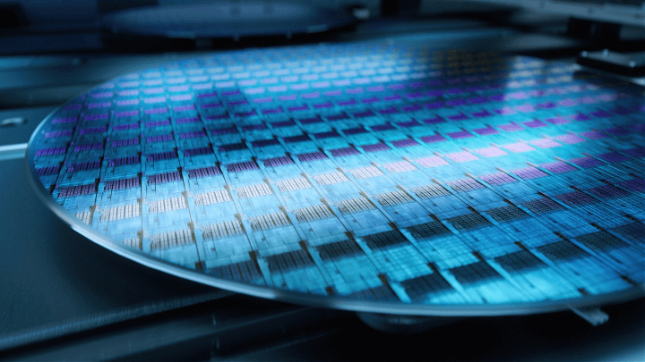 A detailed image of a silicon wafer being manufactured at an advanced semiconductor foundry specializing in microchip production.
