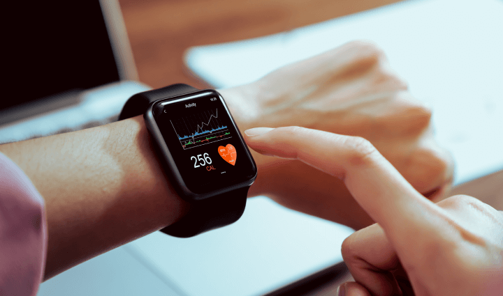 A shot focusing on a hand making contact with a smartwatch displaying a health application, showcasing a device designed for promoting a physically active and healthy lifestyle.
