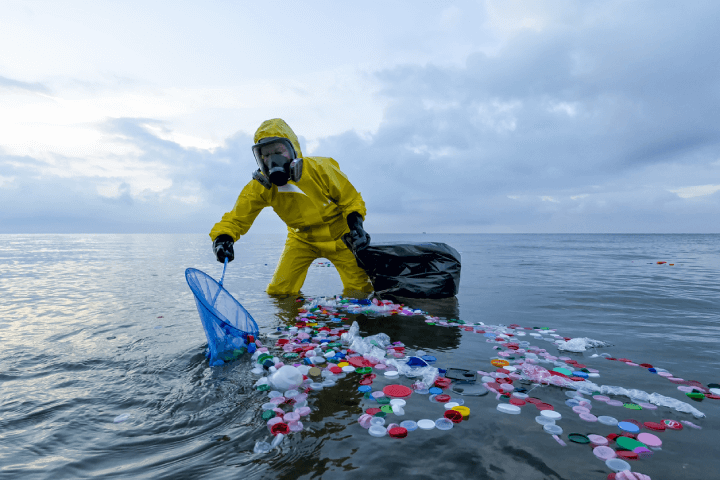 Volunteer biologist is cleaning the ocean, combating plastic pollution and debris, while donning a protective suit and gas mask in response to the contaminated waters.