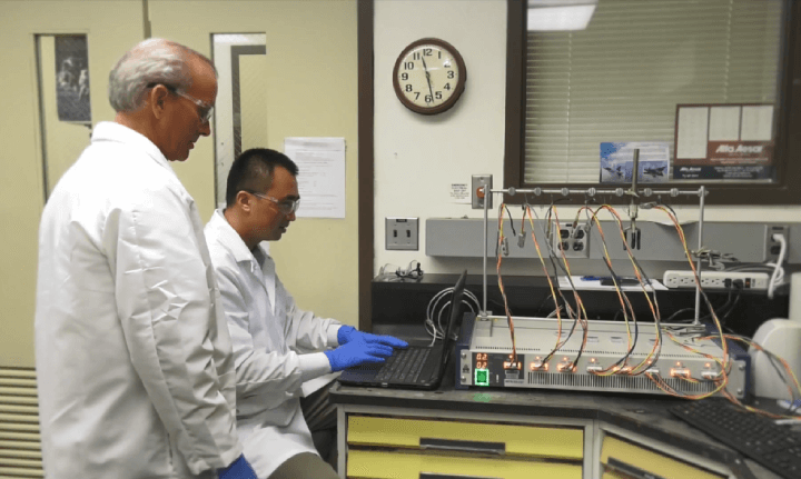 NASA scientists John Connell and Yi Lin seated, using a cyclic voltameter to evaluate a new cathode for SABERS' solid-state aviation battery.